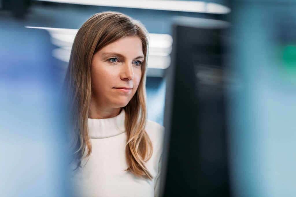 Female worker sits at her computer desktop screen